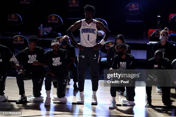 Jonathan Isaac of the Orlando Magic stands as others kneel before the start of a game between the Brooklyn Nets and the Orlando Magic on July 31,...