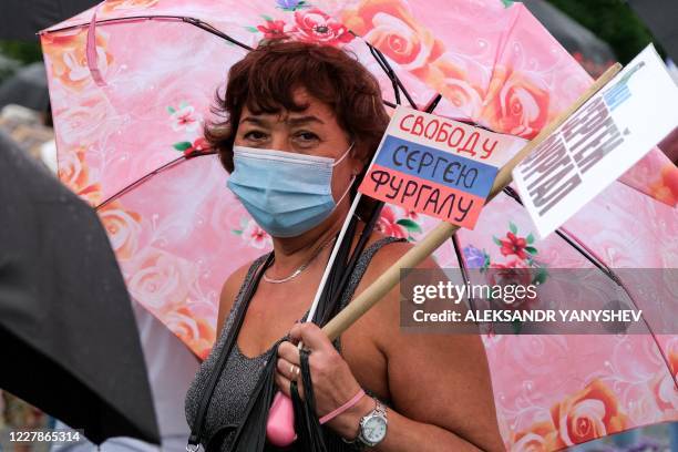 Woman carries a small Russian flag with the lettering reading "Freedom for Sergei Furgal", during an unauthorised rally in support of Sergei Furgal...