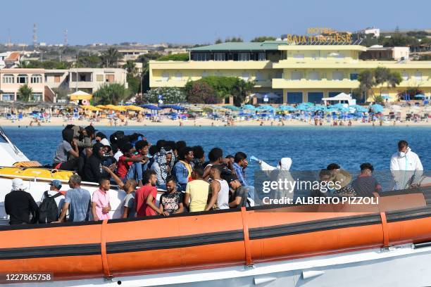 Migrants from Tunisia and Lybia are examined as they arrive onboard of an Italian Guardia Costiera boat in the Italian Pelagie Island of Lampedusa on...