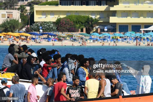 Migrants from Tunisia and Lybia are examined as they arrive onboard of an Italian Guardia Costiera boat in the Italian Pelagie Island of Lampedusa,...