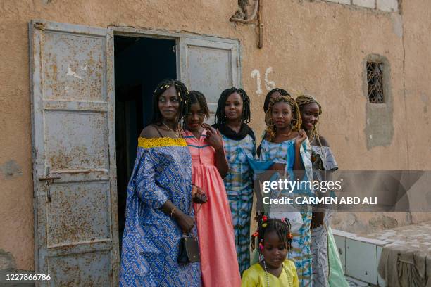Family members pose in front of their house while celebrating Eid al-Adha, also known as Tabaski in Western Africa, in Nouakchott, Mauritania, on...