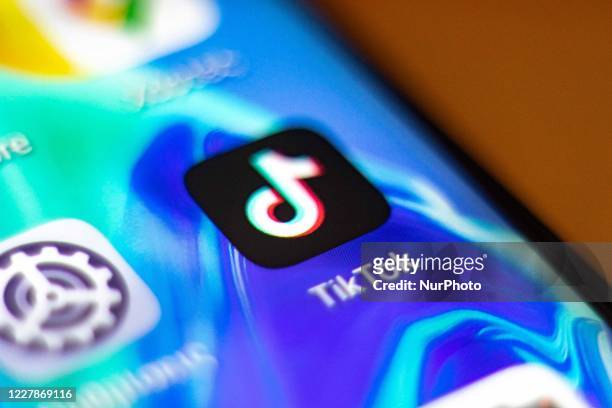 TikTok closeup logo displayed on a phone screen, smartphone and keyboard are seen in this multiple exposure illustration. Tik Tok is a Chinese...