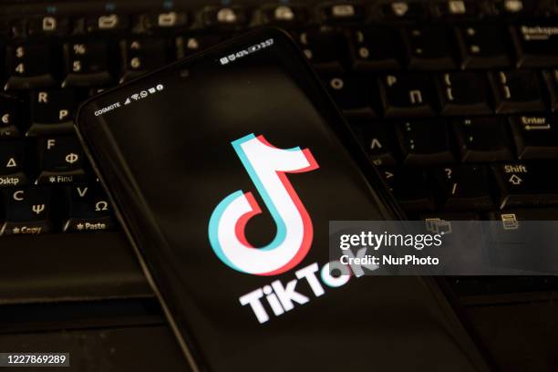 TikTok closeup logo displayed on a phone screen, smartphone and keyboard are seen in this multiple exposure illustration. Tik Tok is a Chinese...