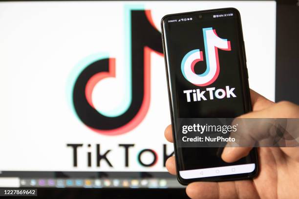 TikTok closeup logo displayed on a phone screen, smartphone and keyboard are seen in this multiple exposure illustration. Tik Tok is a Chinese...