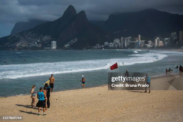 City hall inspectors warn and notify beach goers of new rules at Arpoador beach amidst the coronavirus pandemic on August 1, 2020 in Rio de Janeiro,...