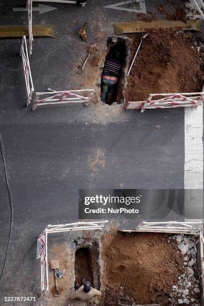 Construction workers repair the asphalt in the City of Buenos Aires, Argentina, on August 1, 2020 during phase 3 of the COVID-19 quarantine. After...