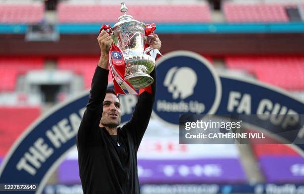 Arsenal's Spanish head coach Mikel Arteta holds the winner's trophy as the team celebrates victory after the English FA Cup final football match...