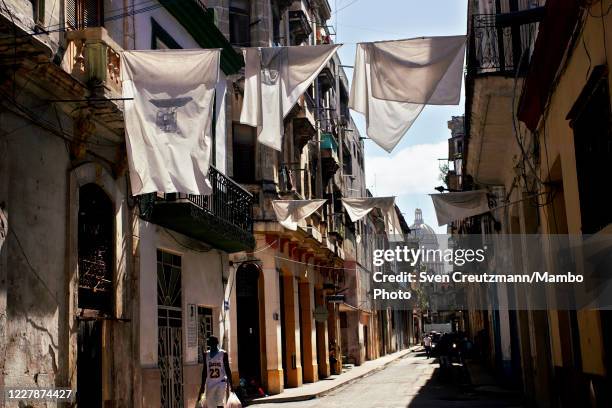 White bedsheets hang from a balcony in Old Havana against the backdrop of the Capitolio, as a tribute to Havanas city historian, late Eusebio Leal on...