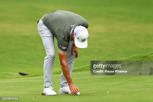 Rickie Fowler places his ball between tees after using the lift, clean and place rule during the third round of the World Golf Championships-FedEx...