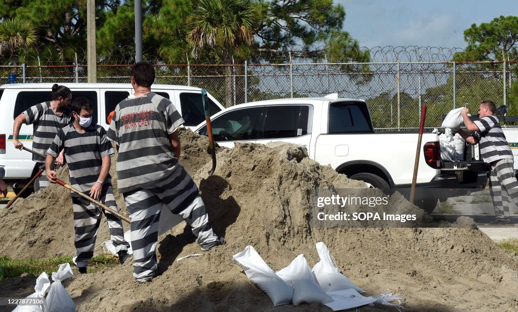 Inmates provided by the Brevard County Sheriff's Office fill sandbags