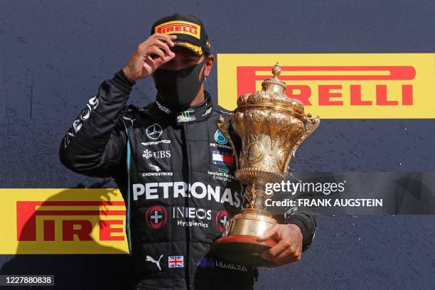 Mercedes' British driver Lewis Hamilton celebrates with his trophy on the podium after the Formula One British Grand Prix at the Silverstone motor...