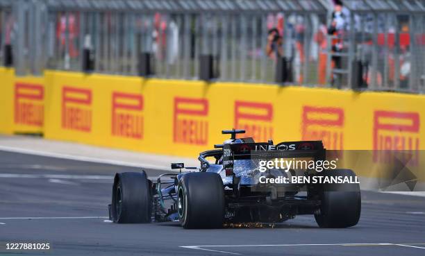 Mercedes' British driver Lewis Hamilton drives with a puncture before winning the Formula One British Grand Prix at the Silverstone motor racing...