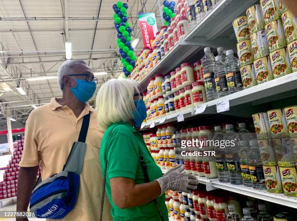 People wearing face masks as a preventive measure against the spread of the novel coronavirus, COVID-19, do their shopping at "Megasis," the first...