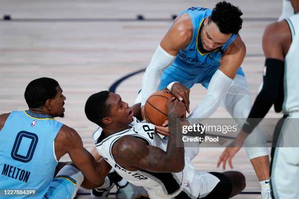 San Antonio Spurs' Lonnie Walker IV, center, scrambles for the ball with Memphis Grizzlies' De'Anthony Melton, left, and Dillon Brooks, right, during...