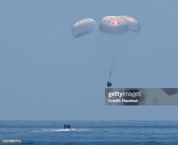 In this handout image provided by NASA, SpaceX's Crew Dragon capsule spacecraft, with NASA astronauts Robert Behnken and Douglas Hurley onboard,...