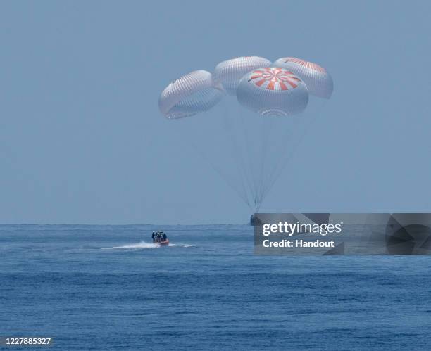 In this handout image provided by NASA, SpaceX's Crew Dragon capsule spacecraft, with NASA astronauts Robert Behnken and Douglas Hurley onboard,...