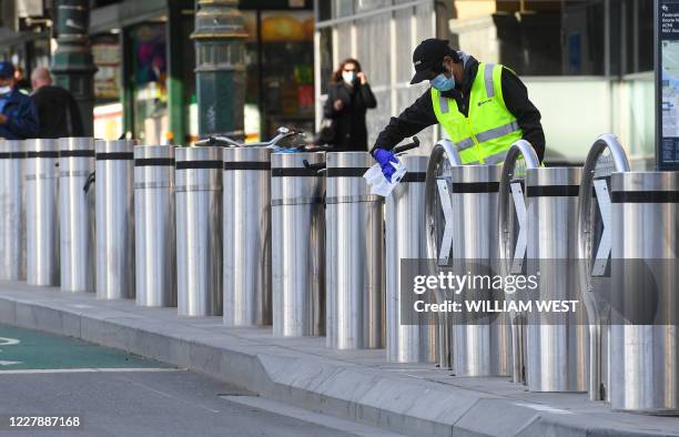 Worker cleans security bollards outside Flinders Street station in Melbourne in August 3, 2020 after the state announced new restrictions as the city...