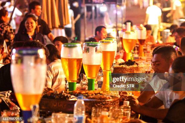 This photo taken on August 1, 2020 shows people enjoying beer and food during the annual Qingdao Beer Festival in Qingdao in China's eastern Shandong...