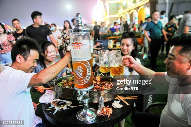 This photo taken on August 1, 2020 shows people enjoying beer and food during the annual Qingdao Beer Festival in Qingdao in China's eastern Shandong...