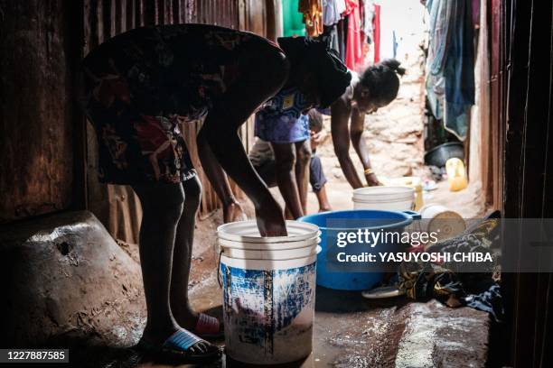 Linet who is in about 3 months pregnant helps to wash cloths after an interview for AFP with her sister Carol about Linet's unexpected pregnancy as...