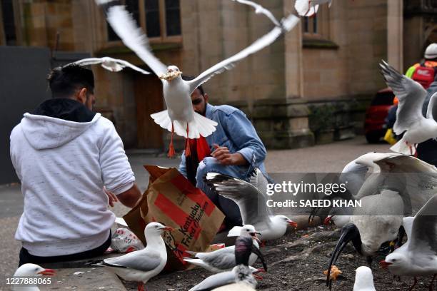 Seagull steals a tourist's food outside a fast food restaurant in Sydney on August 3, 2020.