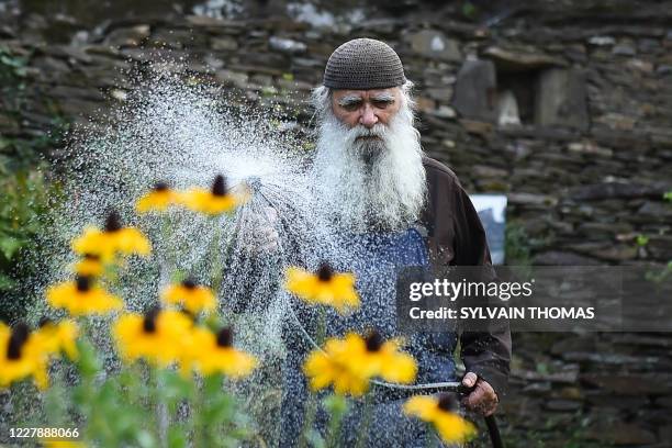Brother Jean, a former French fashion photographer who became an Orthodox monk, water the plants in the vegetables garden in the Skite Sainte Foy...