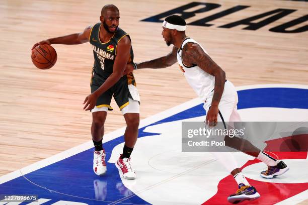 Chris Paul of the Oklahoma City Thunder handles the ball against Torrey Craig of the Denver Nuggets during the third quarter in a NBA basketball game...