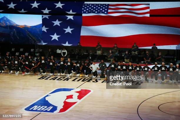 Utah Jazz and Los Angeles Lakers players and staff kneel during the National Anthem before an NBA game at The Arena at ESPN Wide World Of Sports...