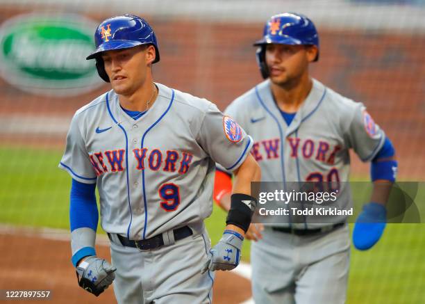 Brian Dozier and Michael Conforto of the New York Mets score on a single off the bat of Robinson Cano in the third inning against the Atlanta Braves...