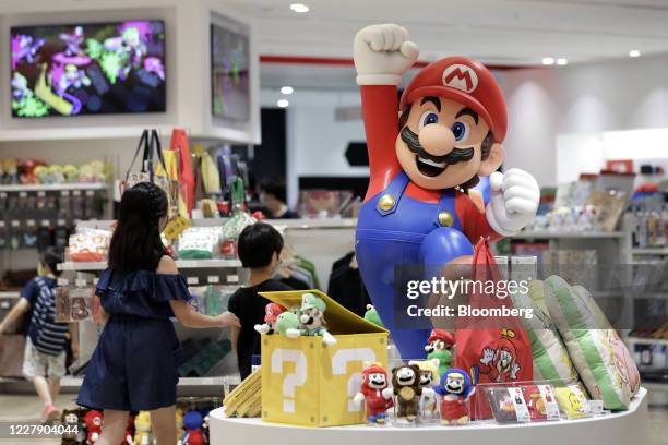Figurine of the Nintendo Co. Video-game Super Mario Brothers character Mario and other merchandise sit on display inside the Nintendo TOKYO store in...