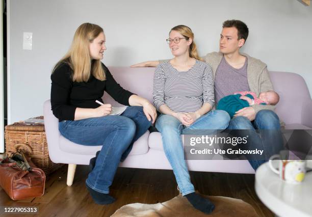 In this photo illustration a midwife is talking to a young couple, that just got parents on March 18, 2019 in Bonn, Germany.