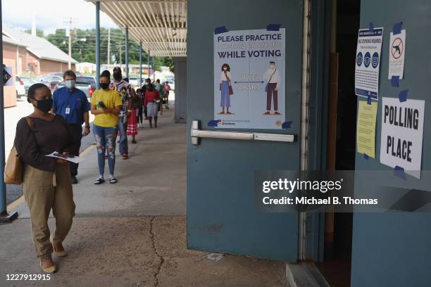 Voters wait in line to enter a polling place at Halls Ferry Elementary on August 4, 2020 in Florissant, Missouri. Primary voters in Arizona, Kansas,...