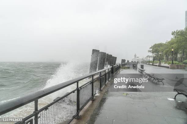 Surging waters from the ocean fueled by strong wind seen on the ground after tropical storm Isaias lashes out New York City as seen in lower...