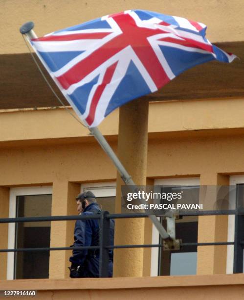 Un membre de la sécurité passe sur un balcon à coté du drapeau britannique le 07 avril 2004 à l'aéroport de Toulouse-Blagnac avant l' arrivée de la...