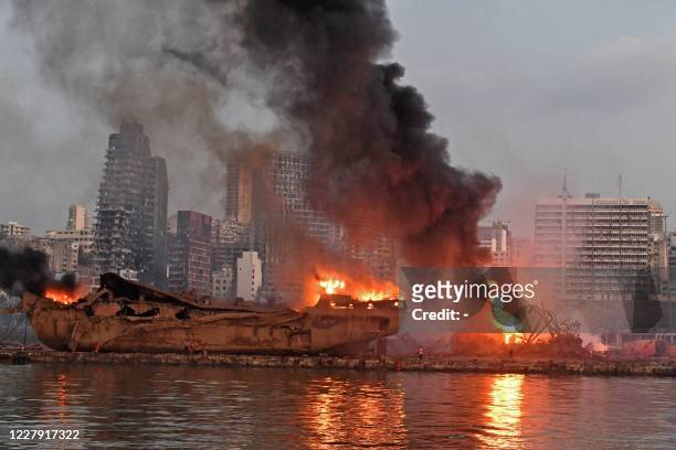 Ship is pictured engulfed in flames at the port of Beirut following a massive explosion that hit the heart of the Lebanese capital on August 4, 2020....