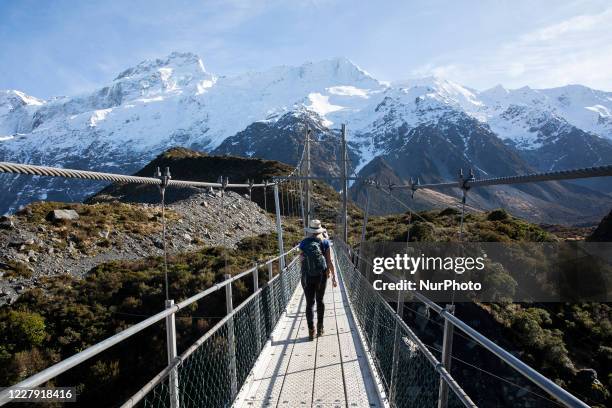 Hikers walk in the Hooker Valley track at Aoraki / Mount Cook National Park in the South Island, New Zealand, on August 05, 2020. The lookout point...