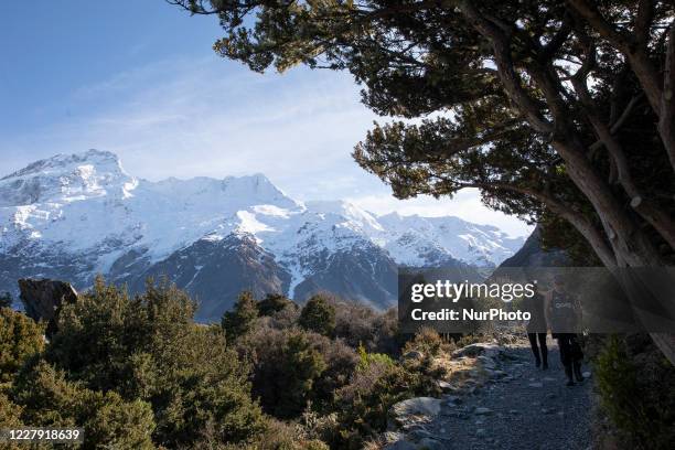 Hikers walk in the Hooker Valley track at Aoraki / Mount Cook National Park in the South Island, New Zealand, on August 05, 2020. The lookout point...