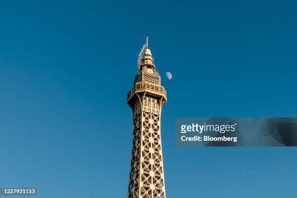 The moon is seen in the sky next to the Eiffel Tower at the Caesars Entertainment Inc. Paris Las Vegas hotel and casino in Las Vegas, Nevada, U.S.,...