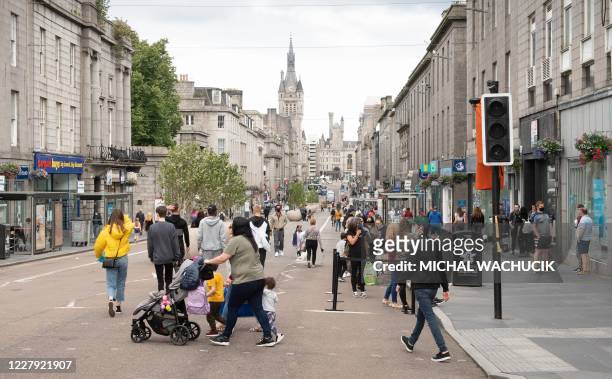 Residents walk in central in Aberdeen, eastern Scotland on August 5, 2020 following the announcement that a local lockdown has been imposed on the...