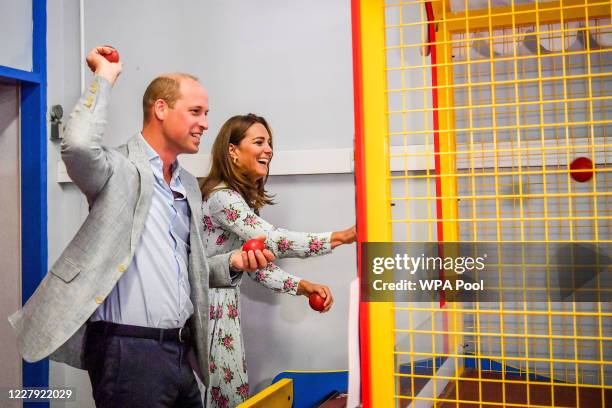 Prince William, Duke of Cambridge and Catherine, Duchess of Cambridge throw balls to knock down figures on an arcade game at Island Leisure Amusement...