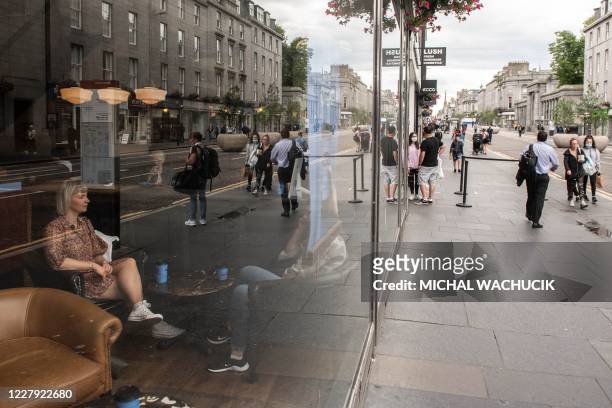 Residents enjoy a coffee in Aberdeen, eastern Scotland on August 5 following the announcement that a local lockdown has been imposed on the city...
