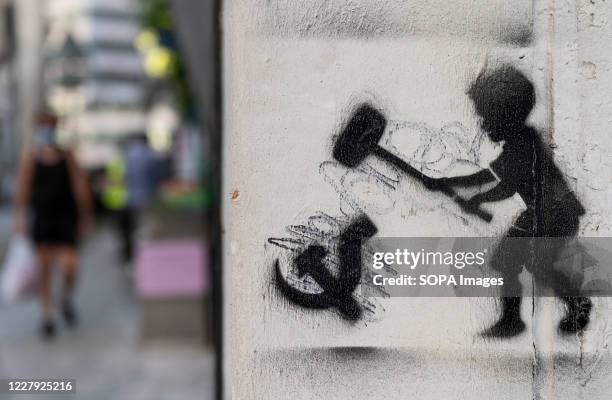 Graffiti is seen depicting a child hammering the communism symbol in Hong Kong.