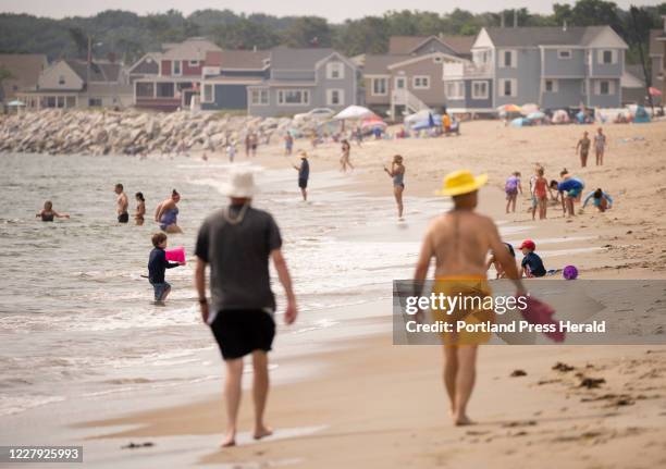 Beachgoers walk and wade at Ferry Beach State Park in Saco on Sunday, August 2, 2020. After the Maine's first fatal shark attack last Monday, off of...