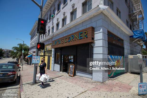 Longtime customer Josefina Reynoso, shown carrying her groceries out, was Lupitas first customer at Lupitas Corner Market And Deli, a family-owned...