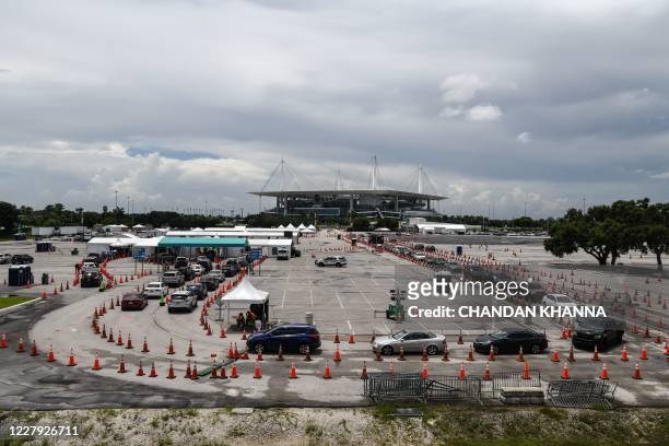Cars line up at a rapid antigen coronavirus testing site at Hard Rock Stadium in Miami Gardens near Miami, on August 5, 2020. - In one of two...