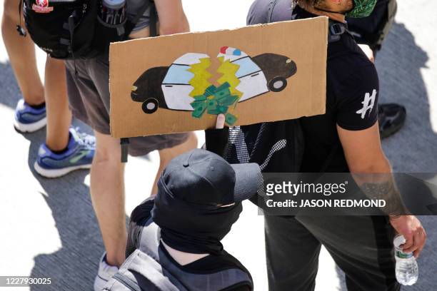 Protester carries a sign during a "Defund the Police" march from King County Youth Jail to City Hall in Seattle, Washington on August 5, 2020.