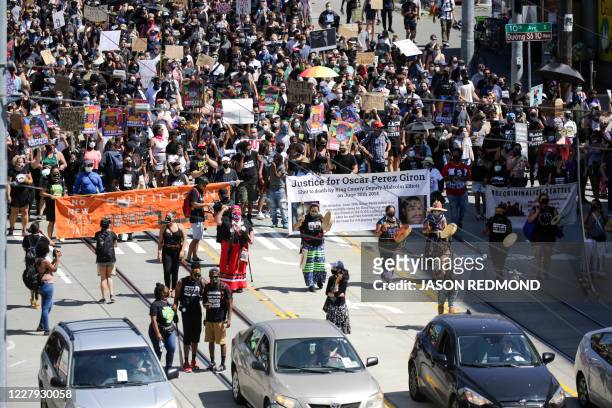 Protesters escorted by a line of cars participate in a "Defund the Police" march from King County Youth Jail to City Hall in Seattle, Washington on...