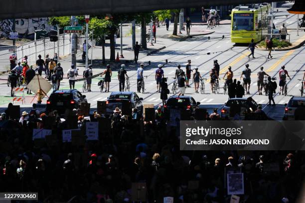 Line of bicycles and cars escorts protesters during a "Defund the Police" march from King County Youth Jail to City Hall in Seattle, Washington on...