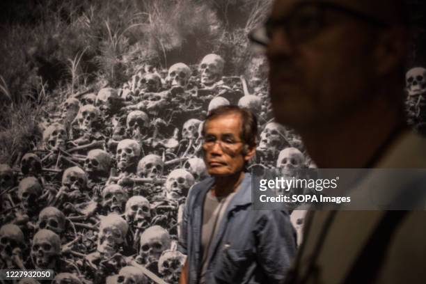 Visitors walk in front of a pictures depicting human skulls dead after the atomic bombing in Hiroshima, at the Hiroshima Peace Memorial Museum. The...