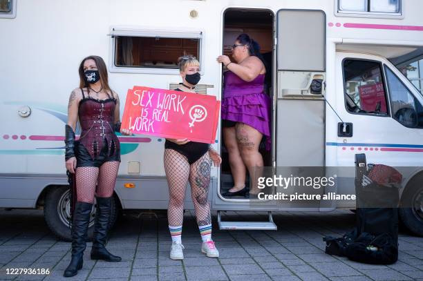 August 2020, Baden-Wuerttemberg, Stuttgart: One participant holds a sign in front of a motor home during a demonstration on the prohibition of sex...